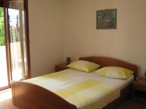 a bedroom with a bed with two yellow pillows at Apartments Blanka in Zadar