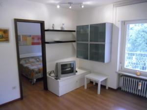 a room with a tv and a bed and a mirror at Garda Blu Apartment in Riva del Garda
