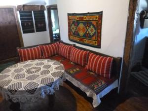 um sofá com almofadas e uma mesa num quarto em Tanya's House em Kŭrpachevo