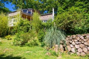 a house with a pile of logs in a yard at Maison des Bois in Bièvres