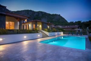 a swimming pool in front of a house at Ville Mirage in Tremezzo