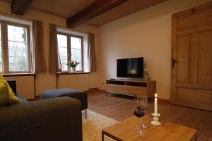 a living room with a television and a candle on a table at Ferienwohnung Suederbootfahrt - Ruheoase für Naturliebhaber in Katingsiel zwischen Tönning und St Peter Ording perfekt für Radtouren in Katingsiel