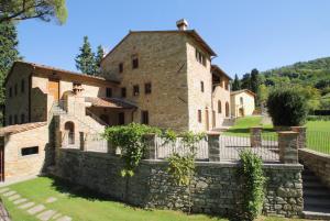 una vecchia casa in pietra con un muro di pietra e scale di Tenuta Poggio Marino a Dicomano