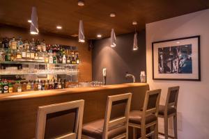 a bar with chairs and bottles of alcohol on the wall at Best Western Plus Hostellerie Du Vallon in Trouville-sur-Mer