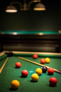 a pool table with balls and cue sticks on it at Best Western Plus Hostellerie Du Vallon in Trouville-sur-Mer