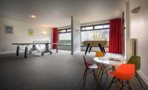 a room with a ping pong table and chairs at Best Western Plus Hostellerie Du Vallon in Trouville-sur-Mer