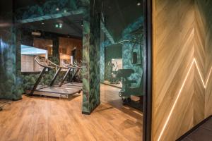 a gym with several exercise equipment in a room at Best Western Plus Hostellerie Du Vallon in Trouville-sur-Mer