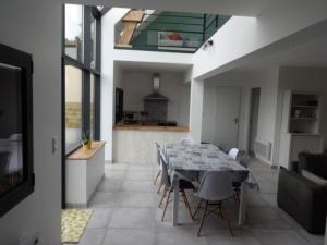 a kitchen and dining room with a table and chairs at Au Coeur des Caps in Audinghen