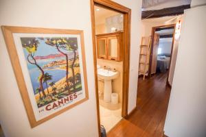 un bagno con un poster appeso al muro e un lavandino di Le Suquet Style by Connexion a Cannes