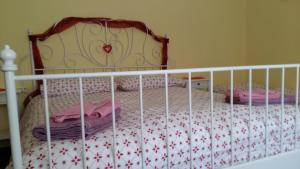un letto con una culla con cuscini rosa di Casa Christine a Genova