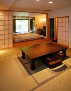 Habitación con mesa, cama y espejo. en Seikansou, en Hakone