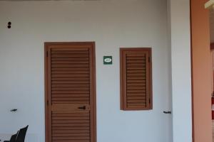 two wooden doors on a wall next to each other at Residence Hotel Torresilvana in Vieste