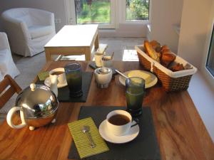 - une table avec du café et des pâtisseries dans l'établissement Maison des Bois, à Bièvres