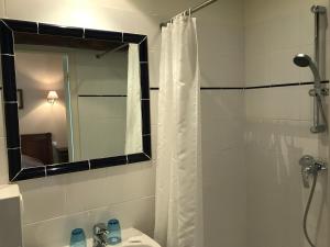 łazienka z zasłoną prysznicową i umywalką w obiekcie Le Parc de l'Hostellerie w mieście Levernois
