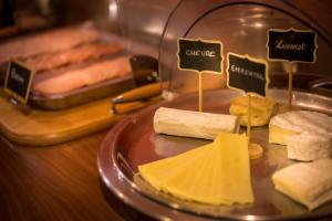 a plate of cheese and bread on a table at Best Western Plus Hostellerie Du Vallon in Trouville-sur-Mer