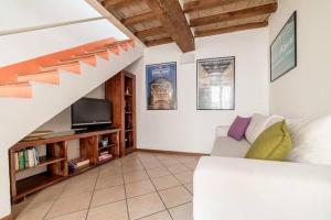 a living room with a white couch and a staircase at Casa della Musica in Parma