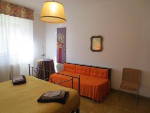 sypialnia z pomarańczową kanapą i krzesłem w obiekcie Villa vista Fiesole we Florencji