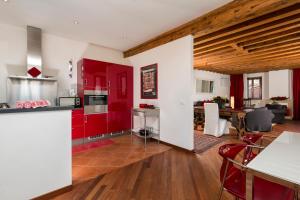 cocina y sala de estar con armarios rojos en Venice Heaven Apartments - Ca Giulia apartment with private living TERRACE on last floor no lift, en Venecia