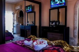 a room with a bed and a tv and mirrors at Sunset Old Town in Ulcinj