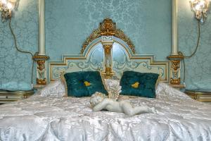 a bed with two pillows and a painting on the wall at Scalon del Doge in Venice
