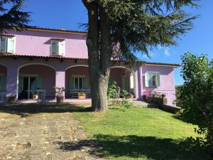 ein rosa Haus mit einem Baum im Hof in der Unterkunft Agriturismo Renaccio in San Lorenzo Nuovo