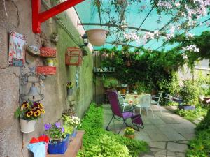 a patio with flowers and a table and chairs at La Roulotte De Lola - Chambre d'hôtes in La Celle