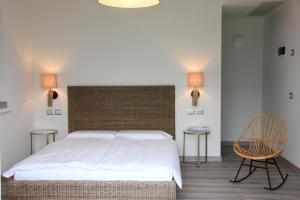 リモーネ・スル・ガルダにあるOlivetoのベッドルーム1室(ベッド1台、テーブル2台、椅子付)
