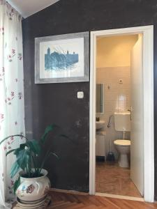 a bathroom with a toilet and a black wall at Apartments Sun in Zadar +37 photos