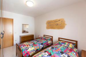 Appartamento Telese Terme في تيليسي: غرفة نوم بسريرين وعلامة على الحائط