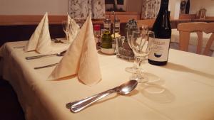 a table with a bottle of wine and wine glasses at Gasthof Specker in Obereggen