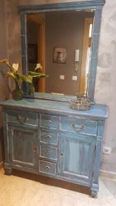 a blue dresser with a mirror on top of it at Apartamentos Andrea in Belmonte de Miranda