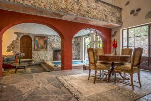 sala de estar con mesa y pared de piedra en Hacienda San Gabriel de las Palmas, en Amacuzac