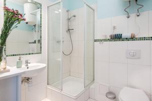 a white bathroom with a shower and a sink at Blue Sky Apartment in Krakow