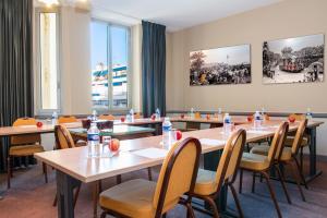 a conference room with tables and chairs and windows at Hôtel Le Royal Promenade des Anglais in Nice