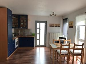 a kitchen with a table and chairs and a kitchen with blue cabinets at Ferienwohnung Happiness in Homburg