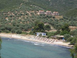a beach with a group of chairs and a resort at House Kokkalas on the beach in Pyrgadikia