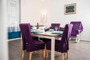 a dining room with a table and purple chairs at Apartment Simone in Split