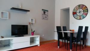 a living room with a tv and a table with chairs at Apartman Sara in Dugi Rat