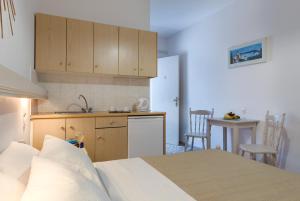 a bedroom with a bed and a small kitchen at Kamarela Studios in Kamari