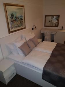 łóżko z białą pościelą i poduszkami w sypialni w obiekcie Hotel Argentum w mieście Vrbnik +29 zdjęć