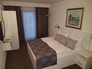 pokój hotelowy z łóżkiem i telewizorem w obiekcie Hotel Argentum w mieście Vrbnik
