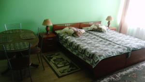 a bedroom with a bed and a table and a table at Apartments on Rizhskaya 10 in Pechory