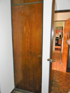 - une porte en bois dans une chambre avec couloir dans l'établissement Habitacion Santo Domingo, Heredia, à Santo Domingo