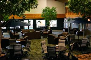eine Lobby mit Stühlen, Tischen und Sonnenschirmen in der Unterkunft Heartland Inn Hotel and Suites in Park Rapids