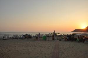 a beach with the sun setting over the ocean at Kleopatra Celine Hotel in Alanya