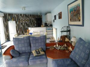 a living room with a couch and a table at Gîte Le Clos des Pins in Colleville-sur-Mer