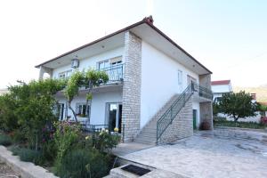 une maison blanche avec un escalier en face de celle-ci dans l'établissement Apartment Marin, à Donji Seget