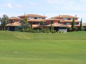 un grupo de casas en una colina con un patio verde en Villa Torremirona Resort Palmeras, en Navata