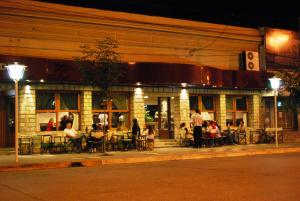 people sitting at tables outside of a restaurant at night at Hotel Ideal Resto Bar in Colorado River