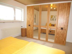 1 dormitorio con armario grande de madera y cama amarilla en Ferienunterkunft Börner en Ehlscheid